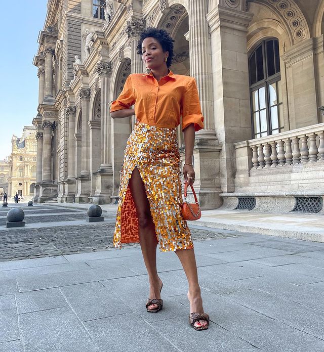 What to Wear to a Summer Wedding: @SLIPINTOSTYLE wears a sequin midi skirt with an orange shirt