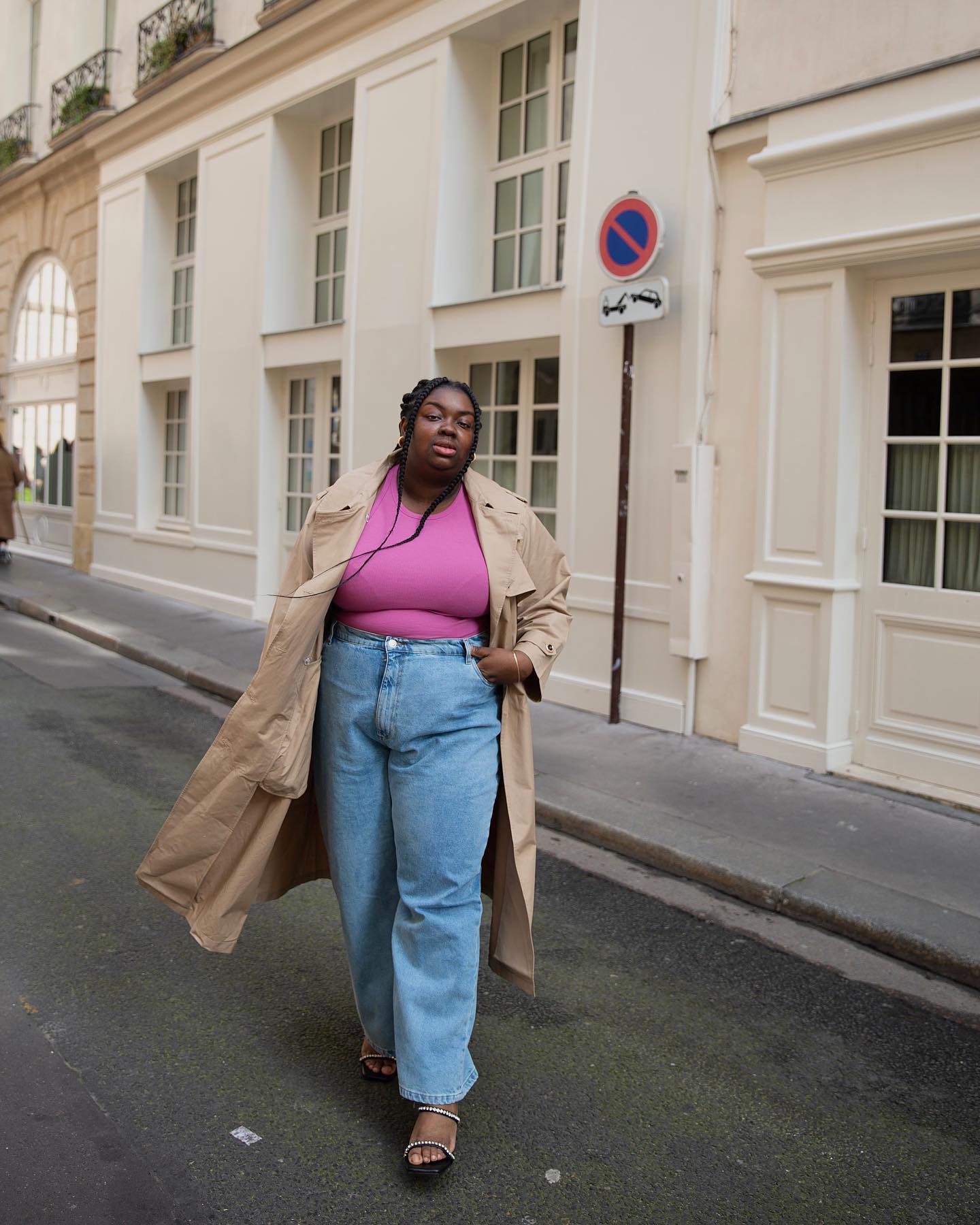 Abisola wearing pink top with trench coat and baggy jeans