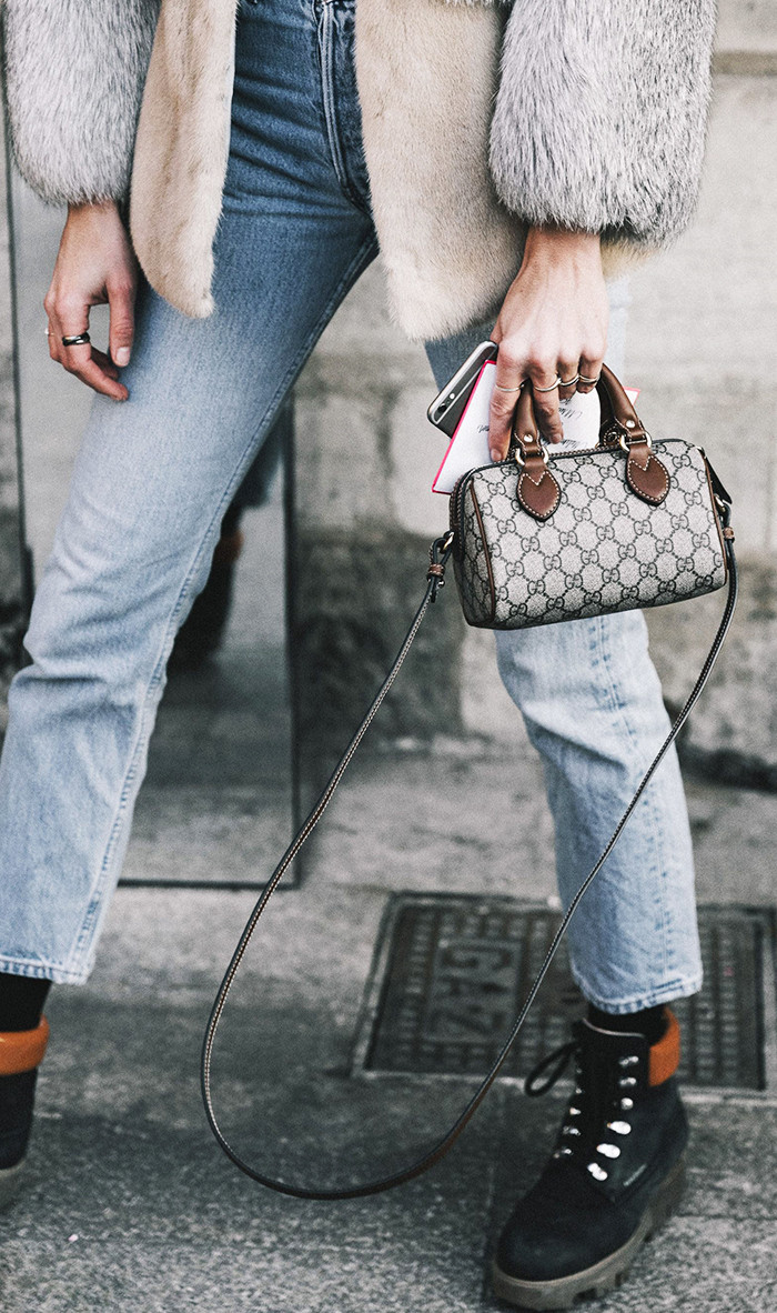 Woman wearing Gucci baby bag with fur and denim
