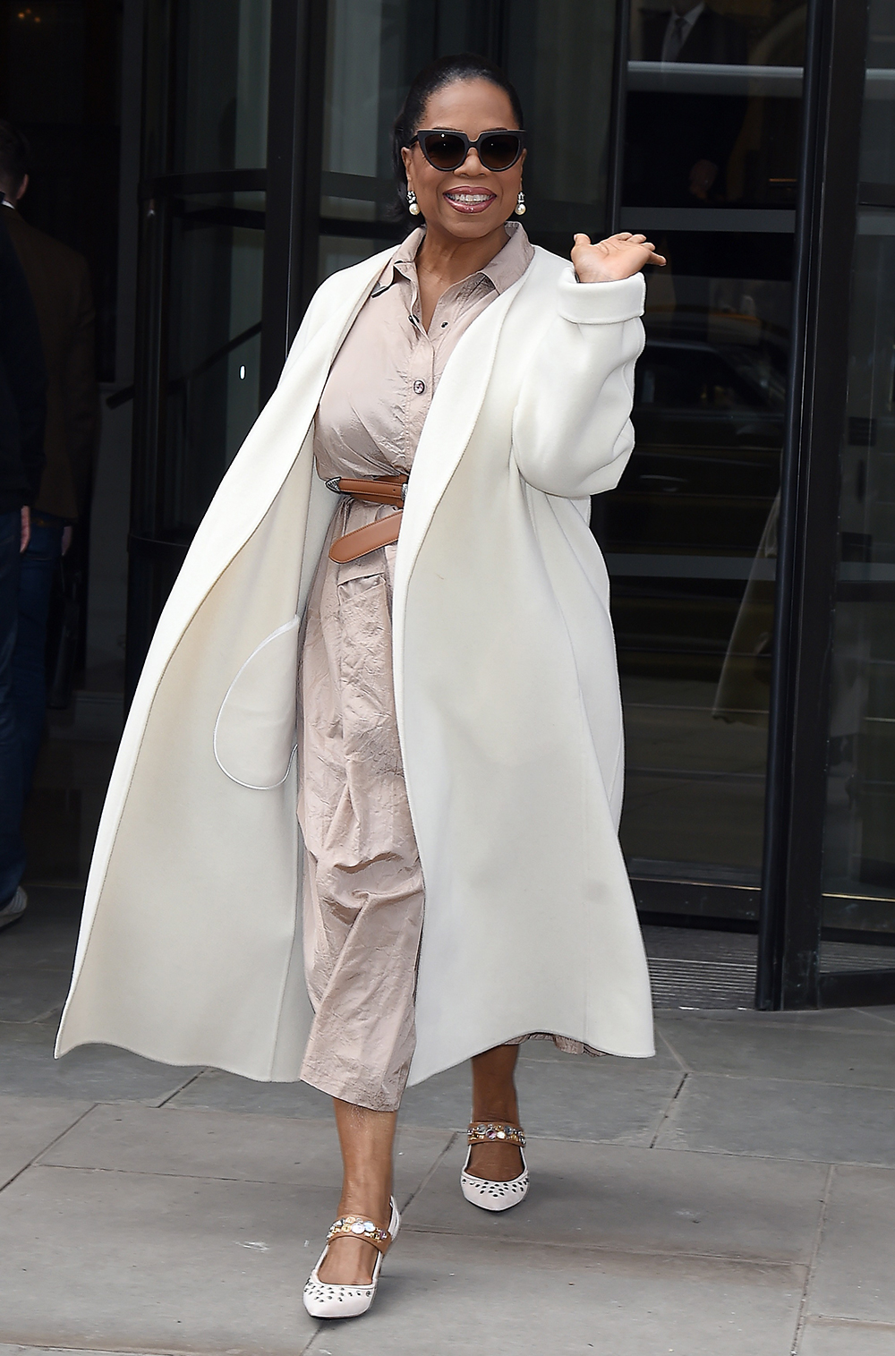 Over 50 fashion and clothing inspiration: Oprah wearing a white coat with a beige shirt dress and kitten heel pumps