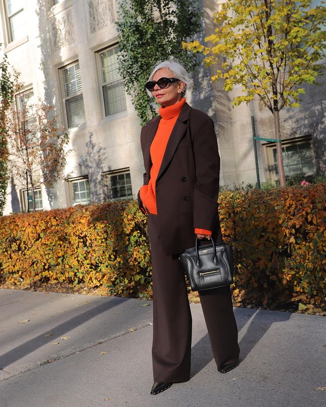 Autumn Work Outfits: @greceghanem wears a brown suit and orange jumper