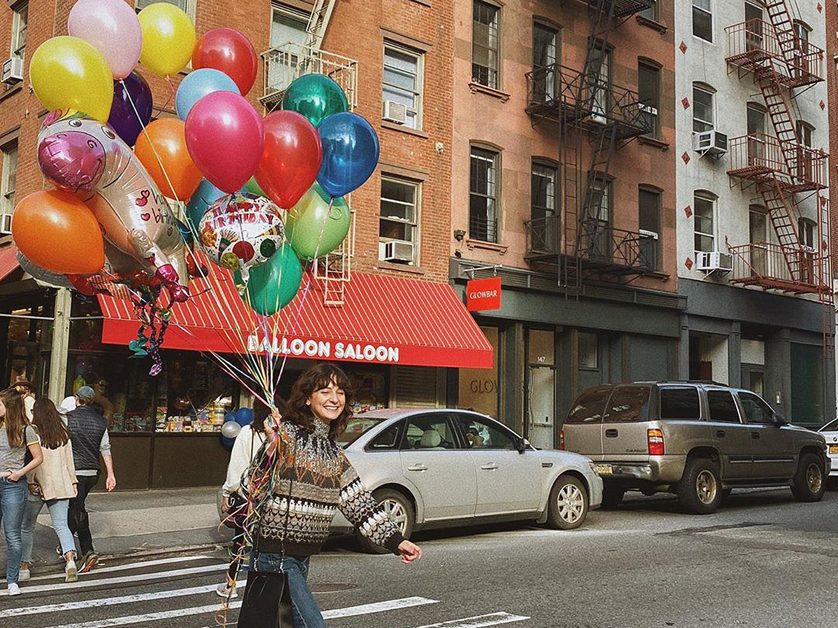 Girl carrying balloons