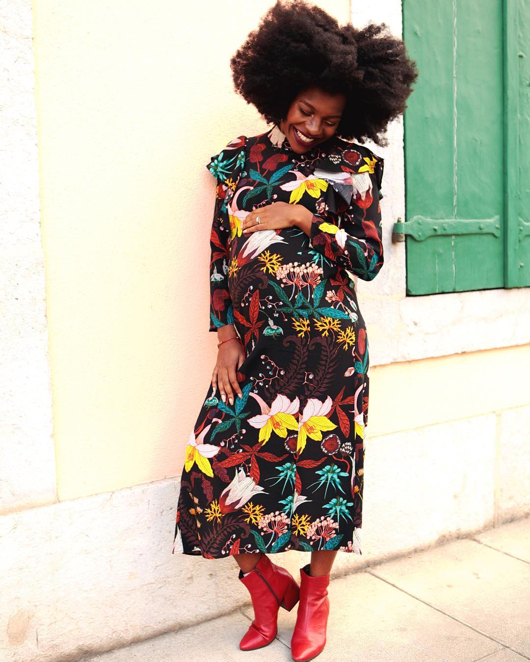 Pregnancy skincare: Freddie Harrel wearing floral midi dress and red boots