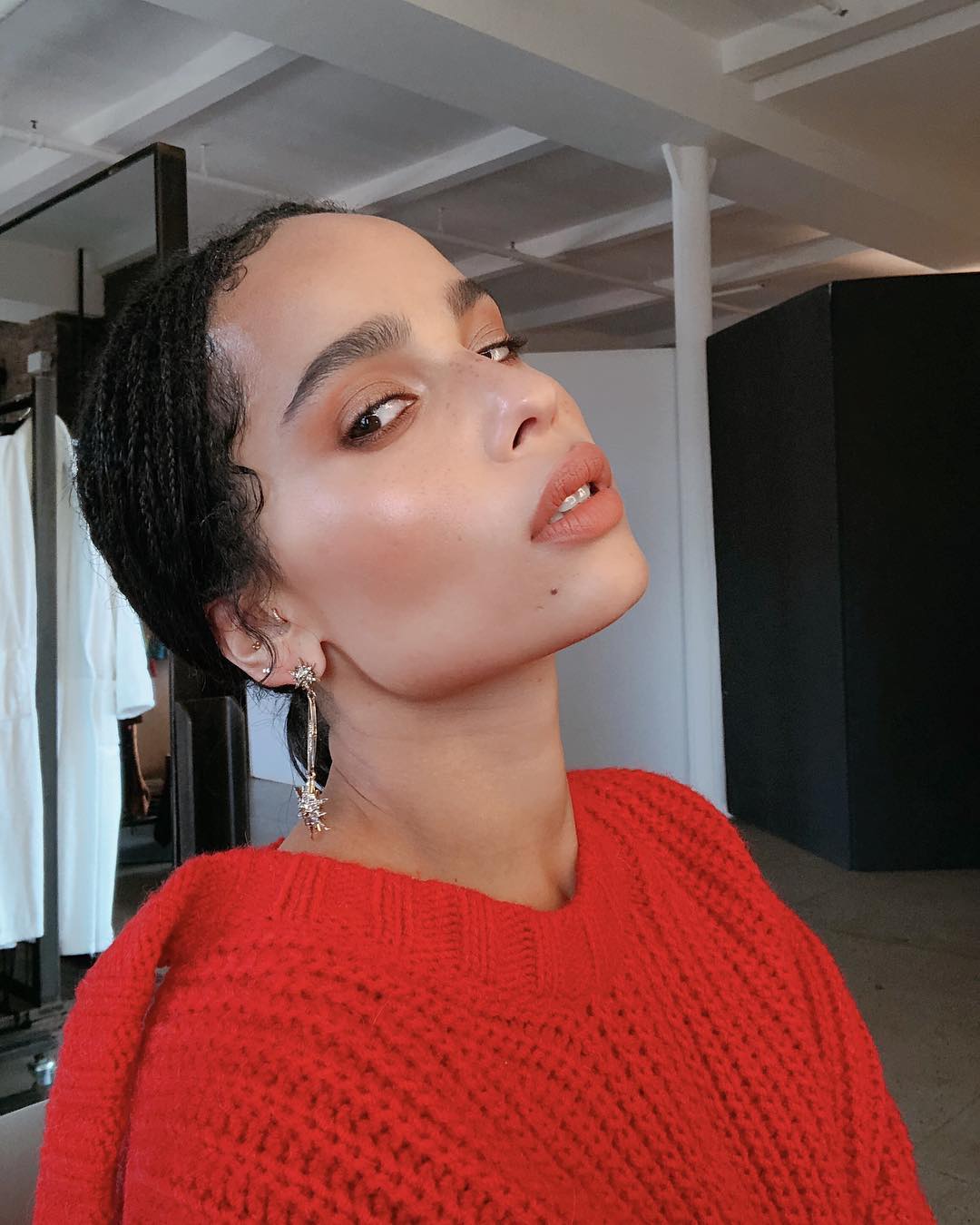 Summer Hairstyles: Zoë Kravitz wearing a low ponytail and red jumper