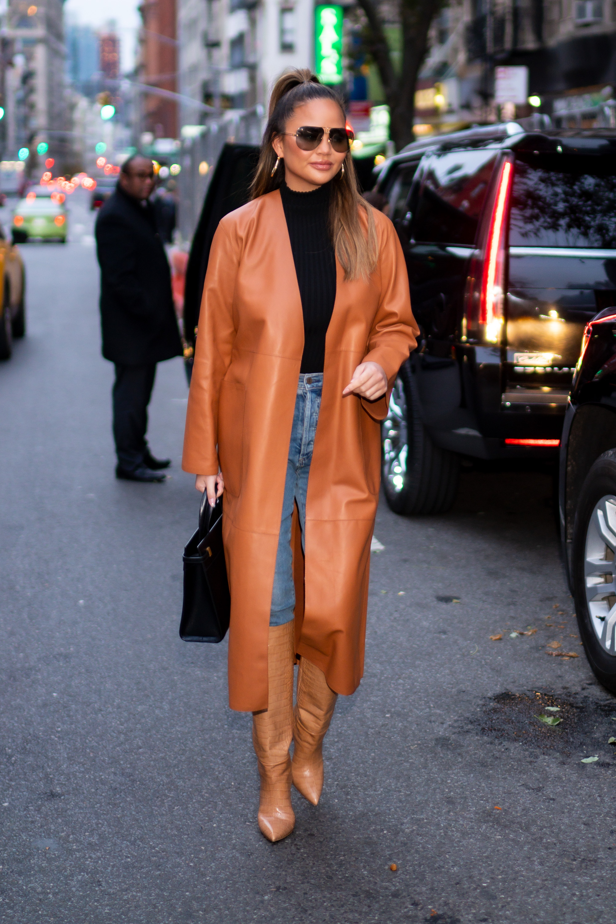 Chrissy Teigen outfit wearing jeans and boots