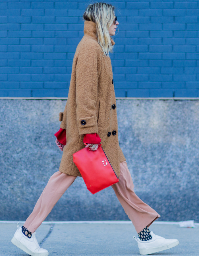 best street style outfits: camile charriere wearing a loose-fitting trousers and brightly coloured pink bag