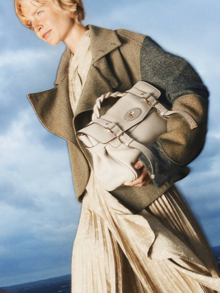 mulberry alexa bag: model wears a grey mulberry alexa bag with a brown jacket and pleated skirt