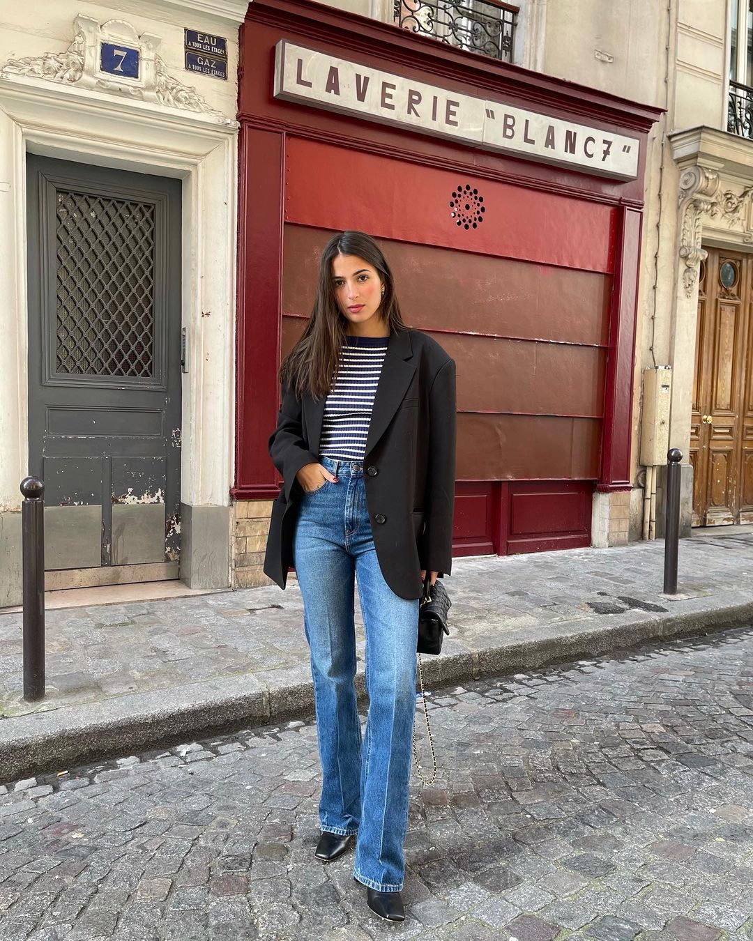 French Fashion Essentials: @tamaramory wears a pair of flared jeans with a black blazer and Breton stripe tee
