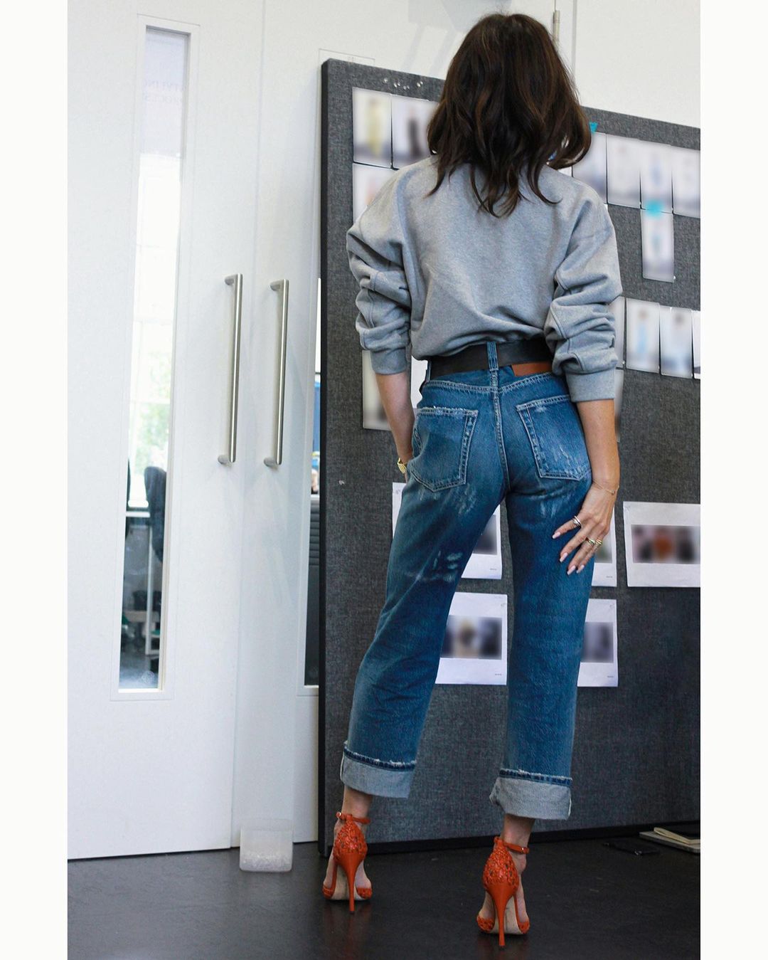 Victoria Beckham jeans and sweatshirt and red heels: