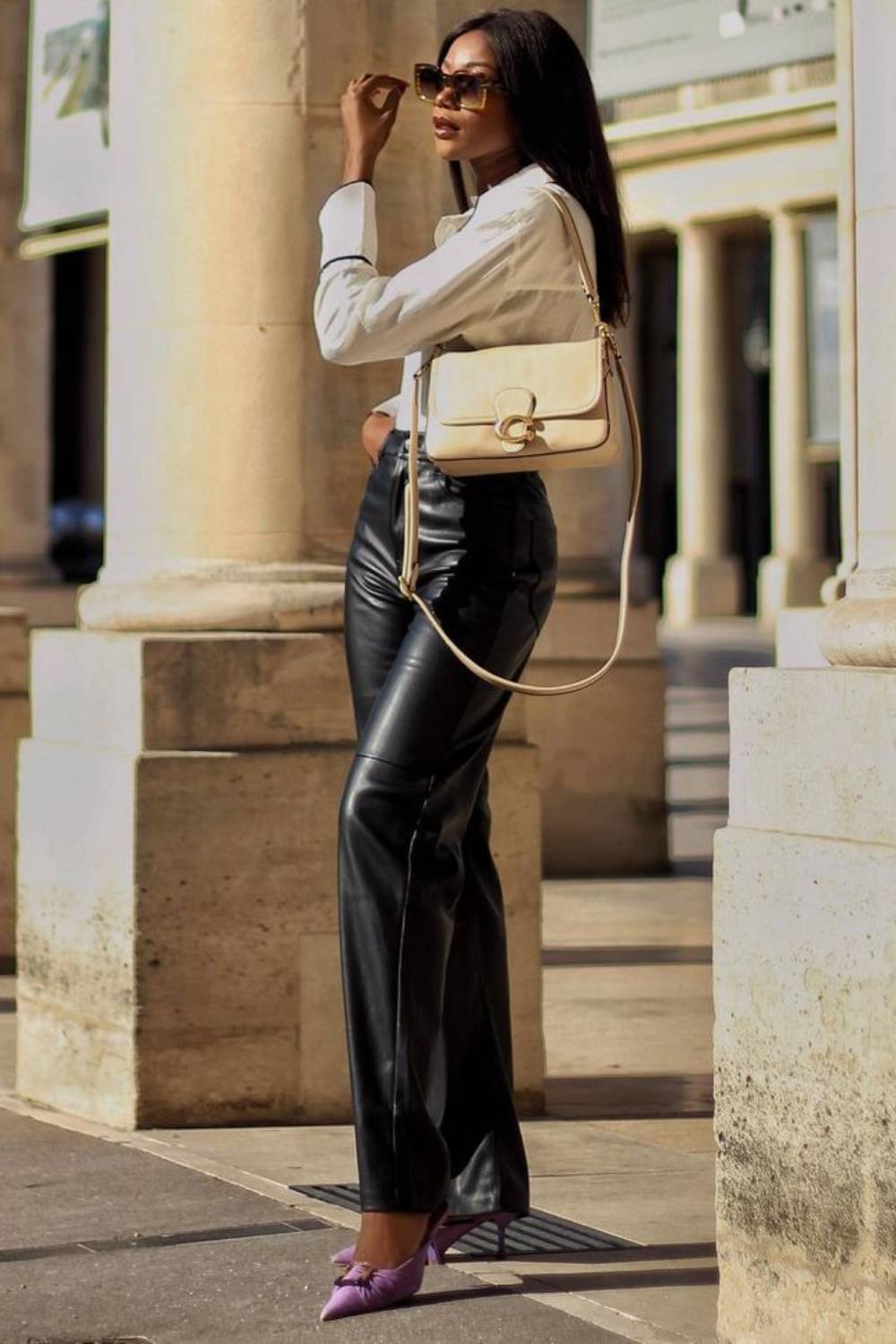 Andrea Mun wearing white top and leather trousers with heels