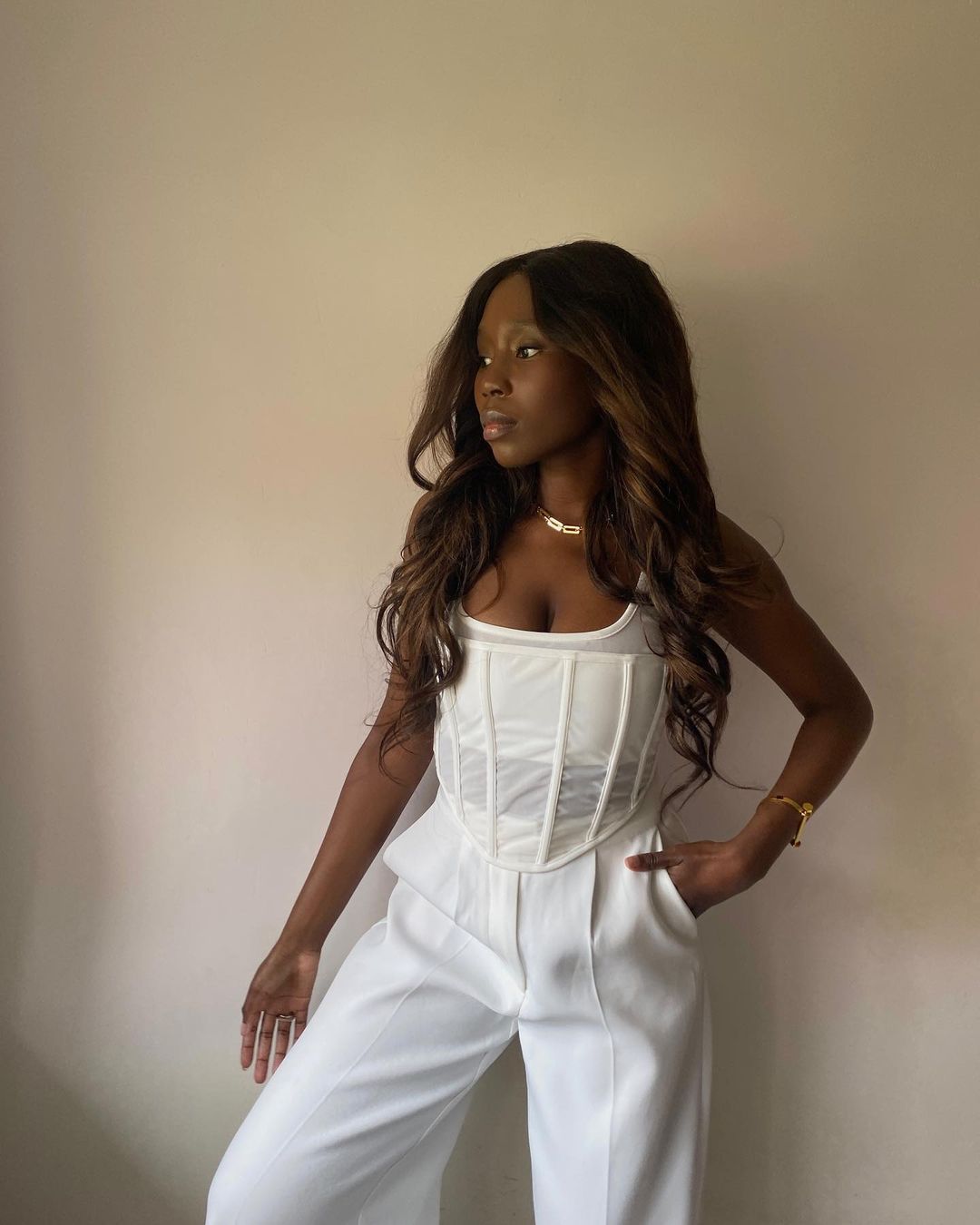 Corset Top Outfits: @daniellejinadu wears a white corset top with white wide-leg trousers