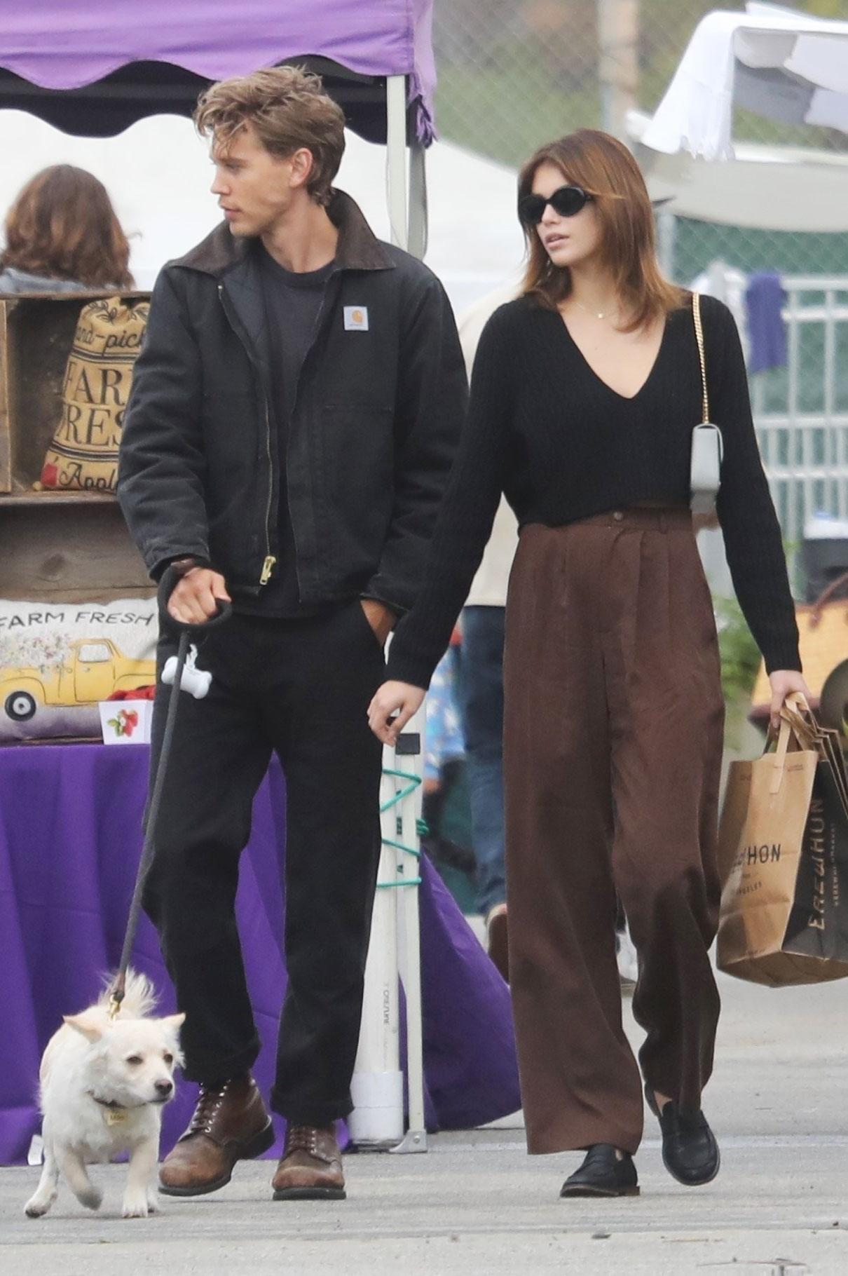 Kaia Gerber wearing brown pants Reformation trousers with flat loafers