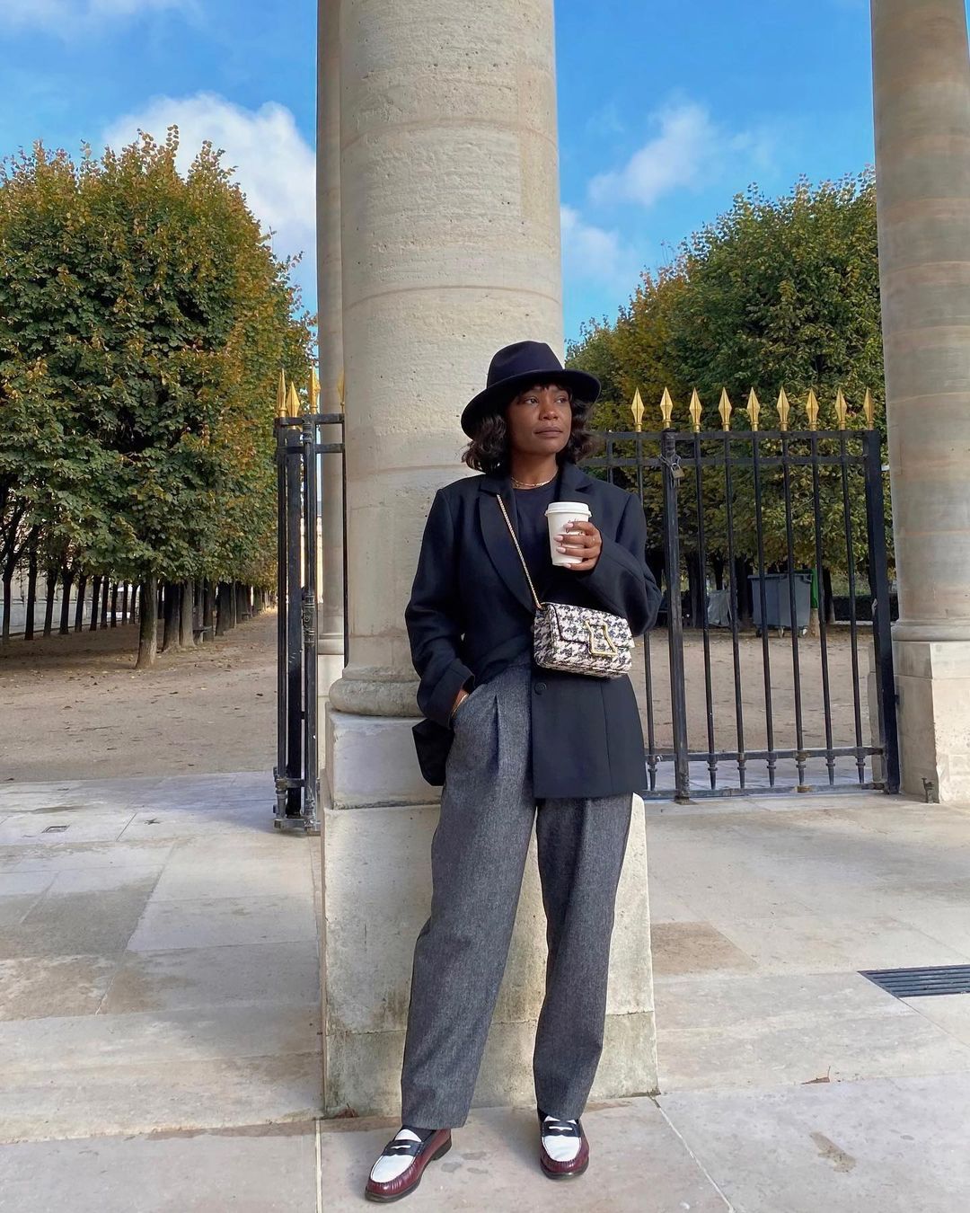 French girl autumn shoes: @frannfyne wears flat loafers with tailored grey trousers, a blazer and a cross-body tweed bag
