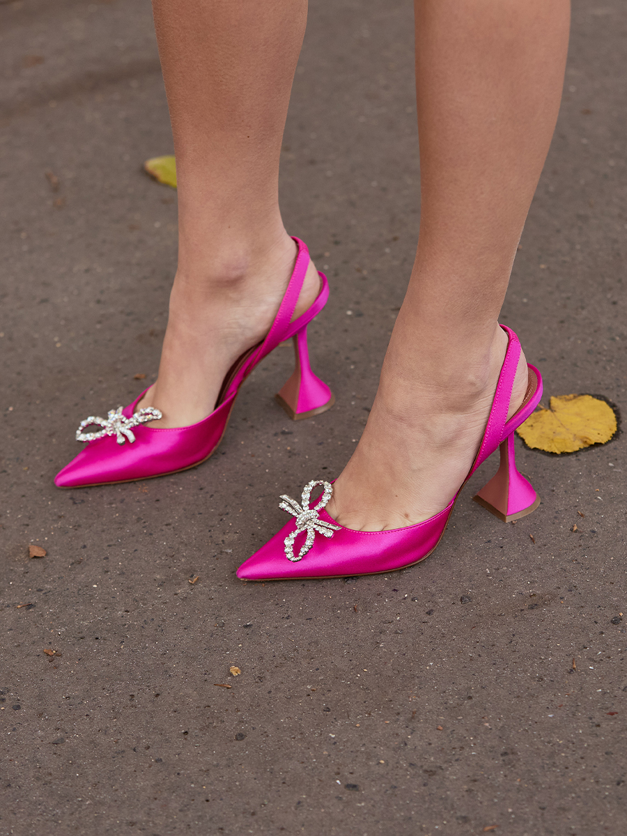 Атласные туфли на каблуке цвета фуксии с украшением в виде банта из кристаллов.