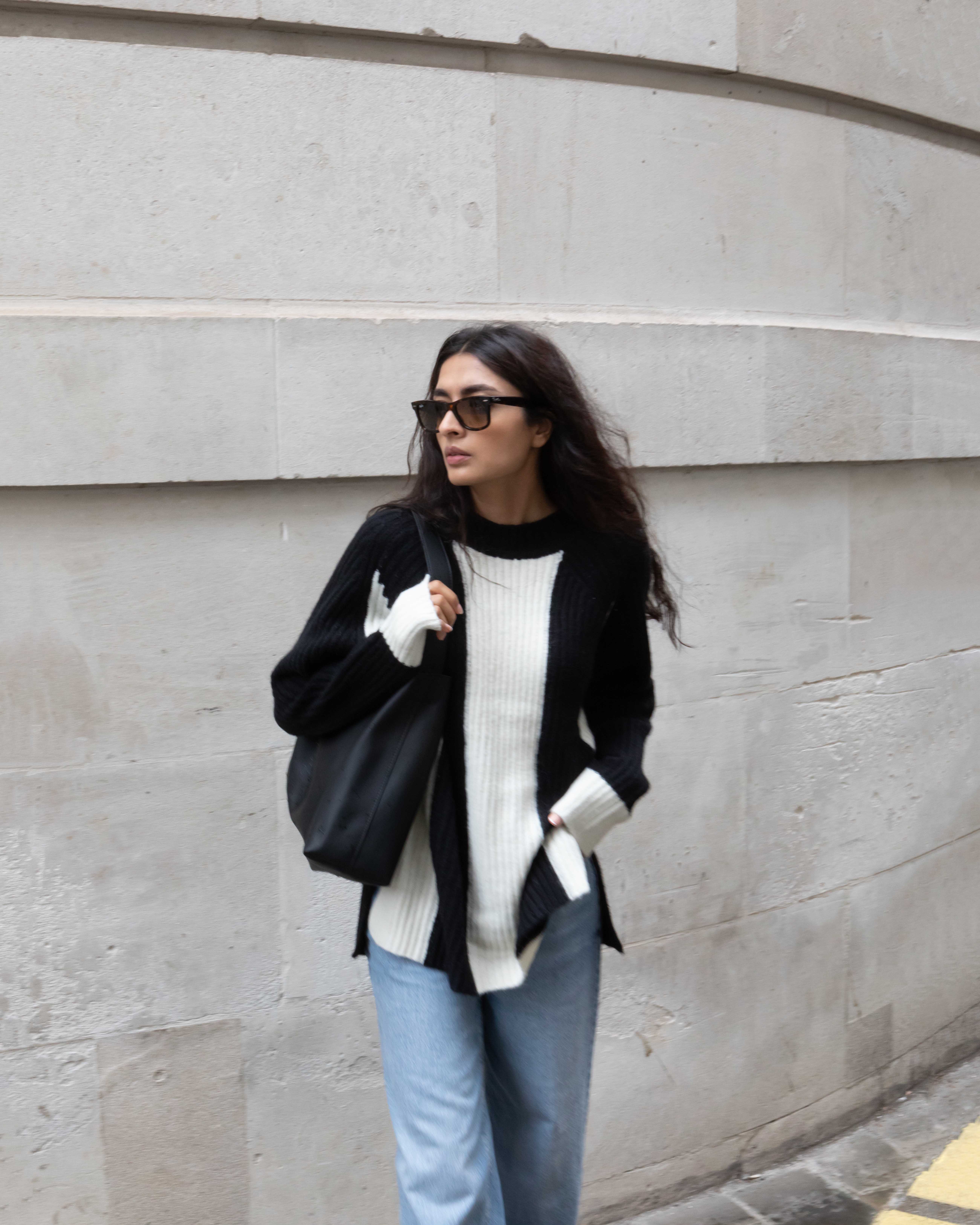 Influencer Yatri wears Marks & Spencer's block-stripe jumper with blue jeans and a black leather bag