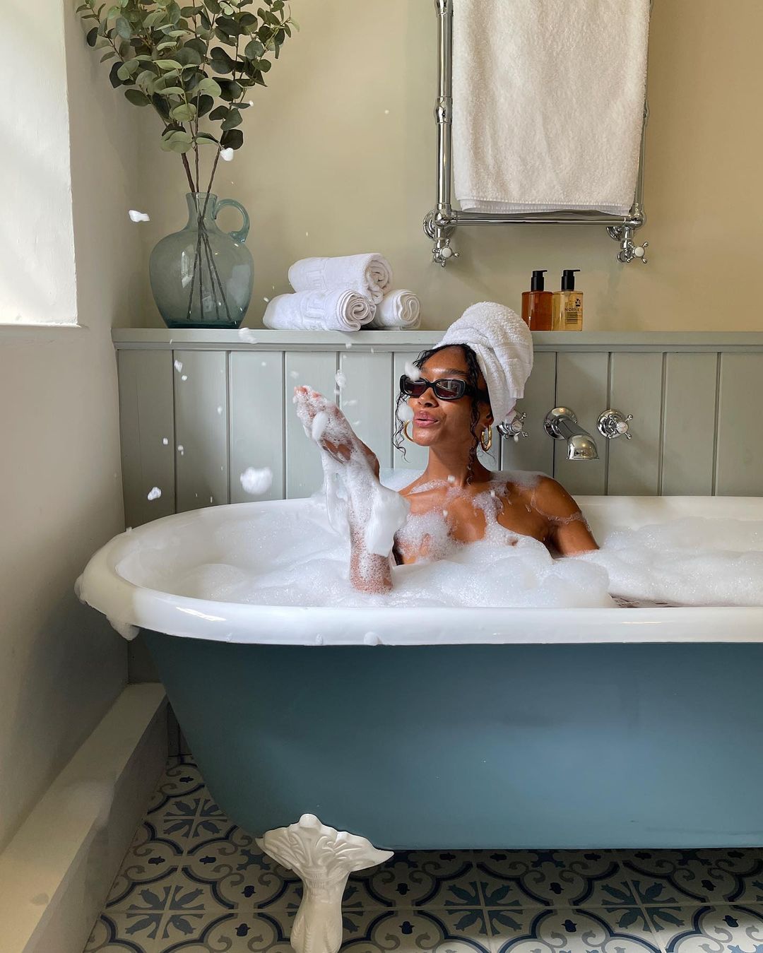 Best & other Stories bath and body products: Woman in clawfoot bathtub with bubble bath