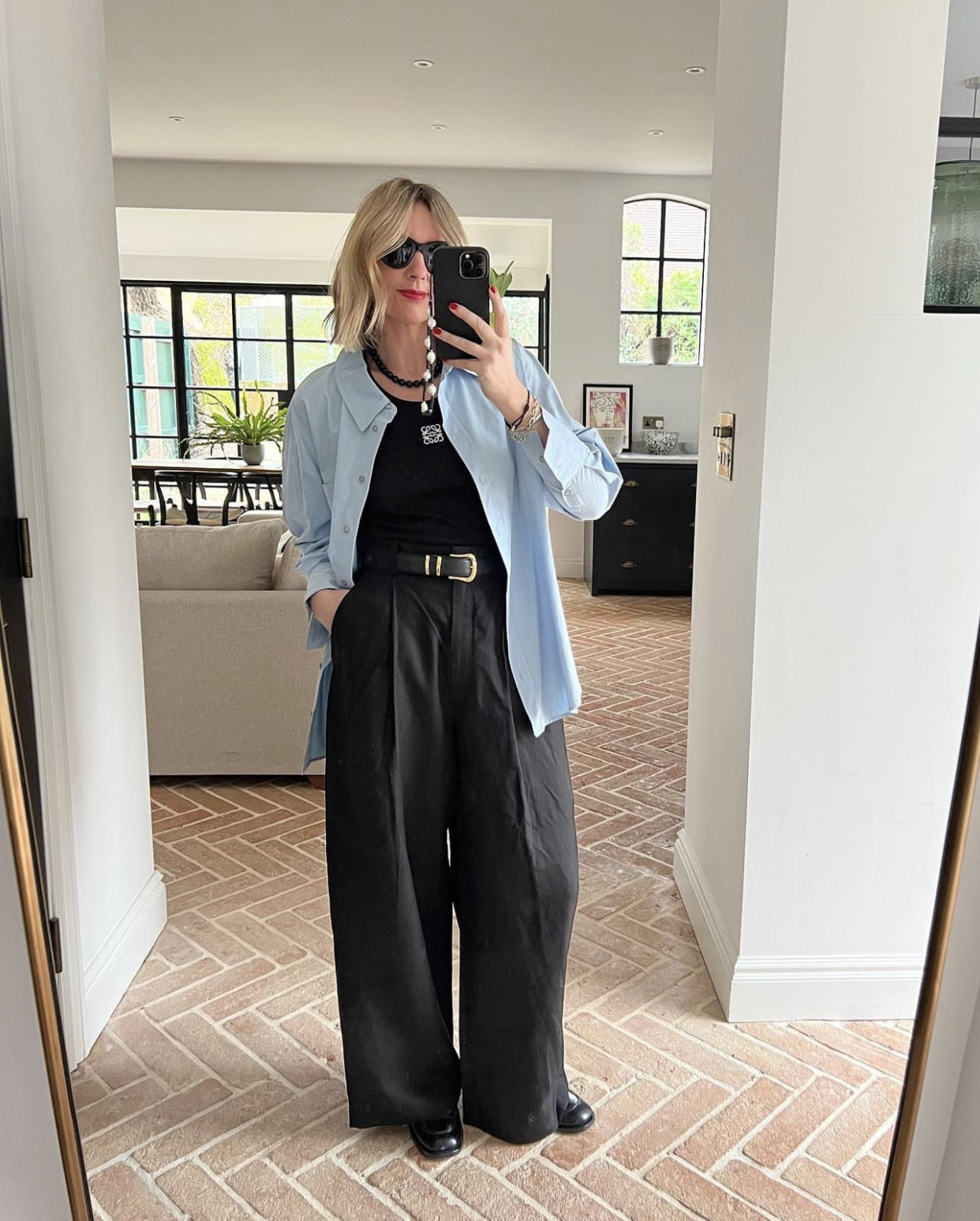The Best black trousers for women: @emmarosestyle wears high-waisted, wide-leg trousers and a blue poplin shirt