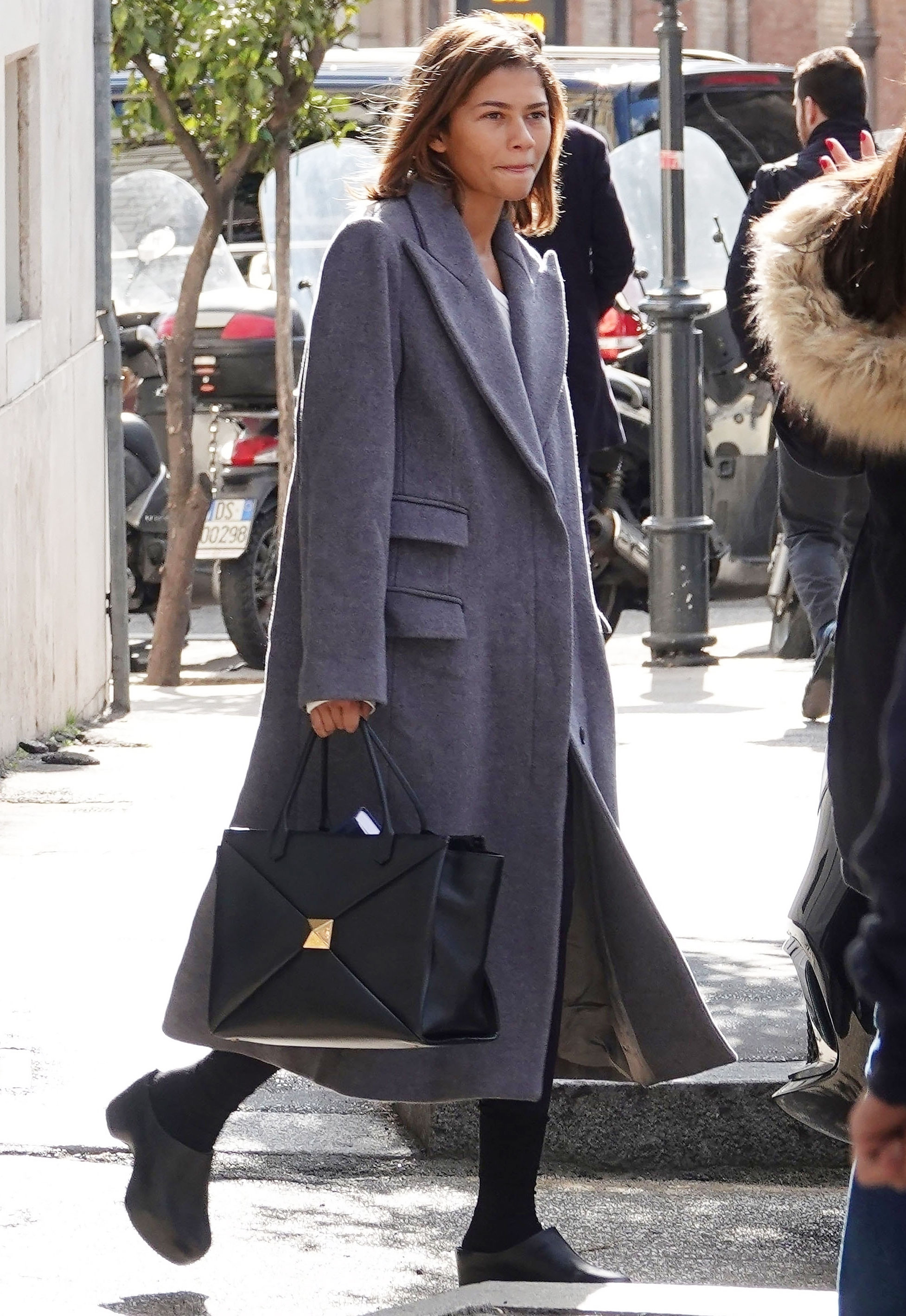 zendaya wearing a valentino tote bag and gray coat