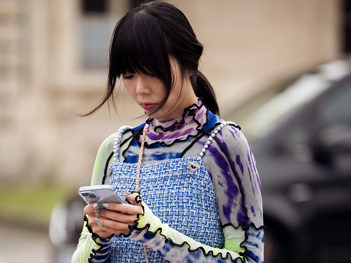 Girl wearing Chanel looking at phone
