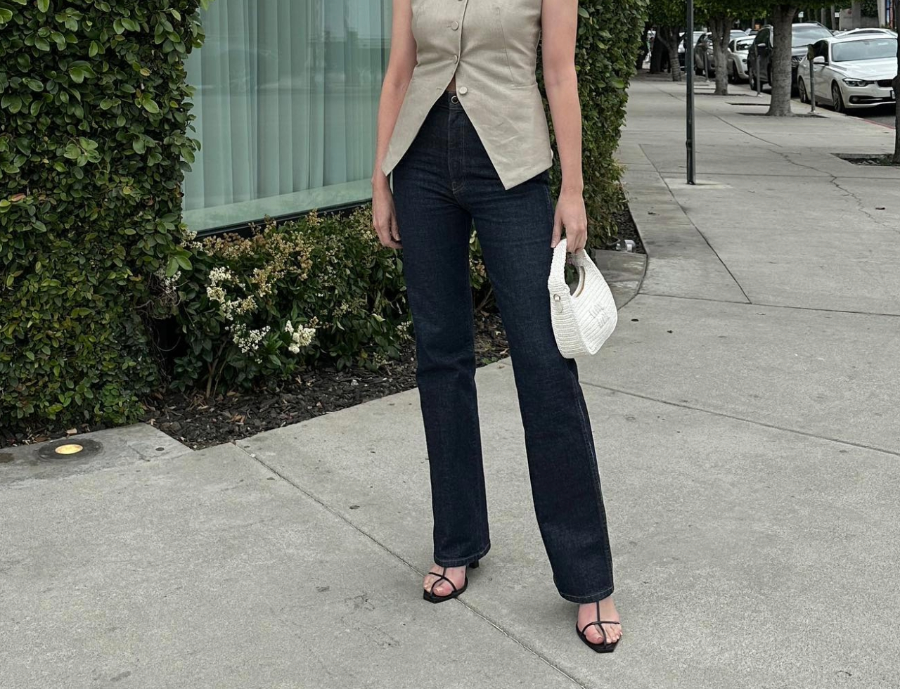@kristenmarienichols wearing Madewell jeans with a vest and sandals.