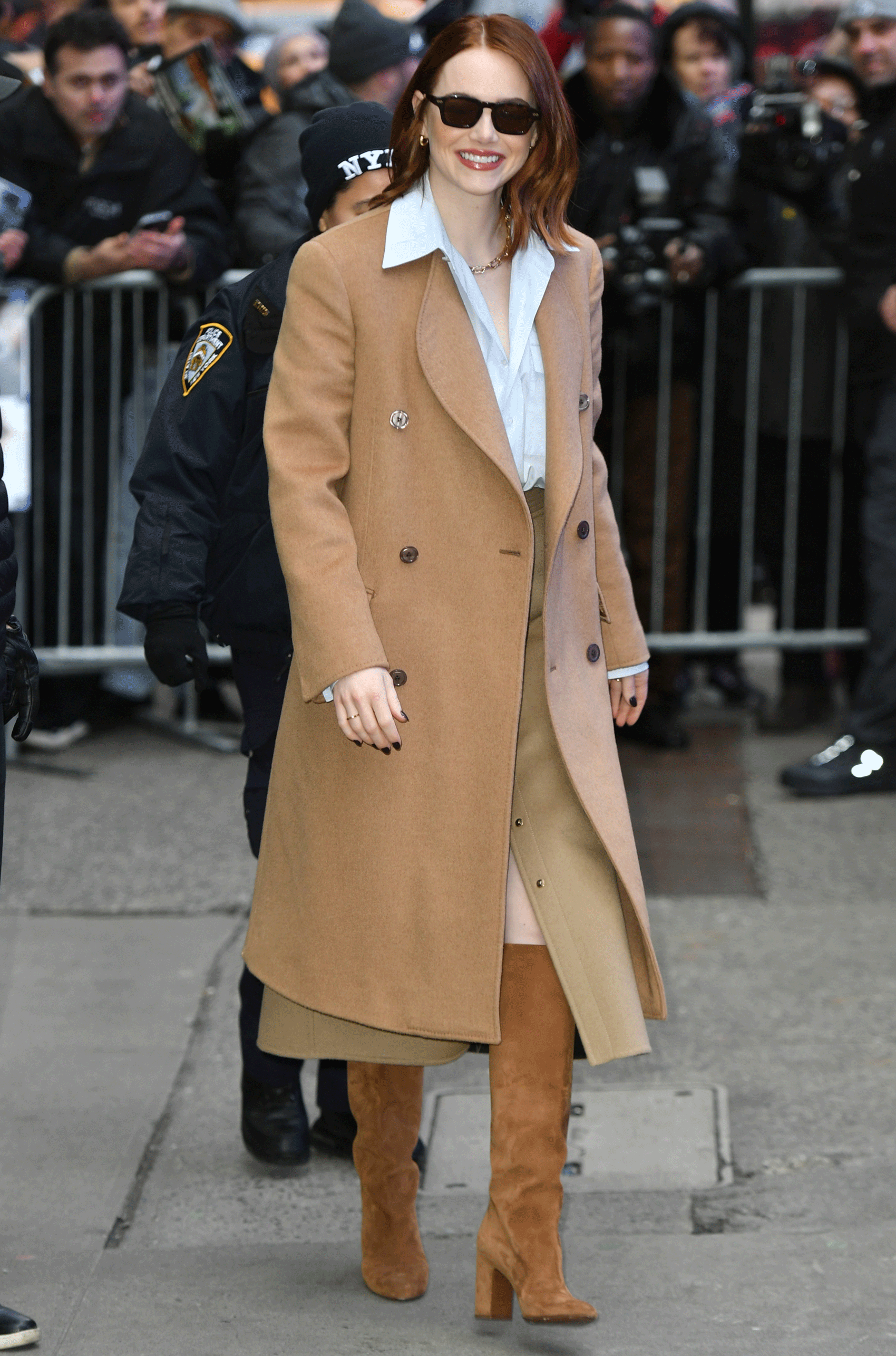 emma stone wearing a tan coat and suede boots by louis vuitton